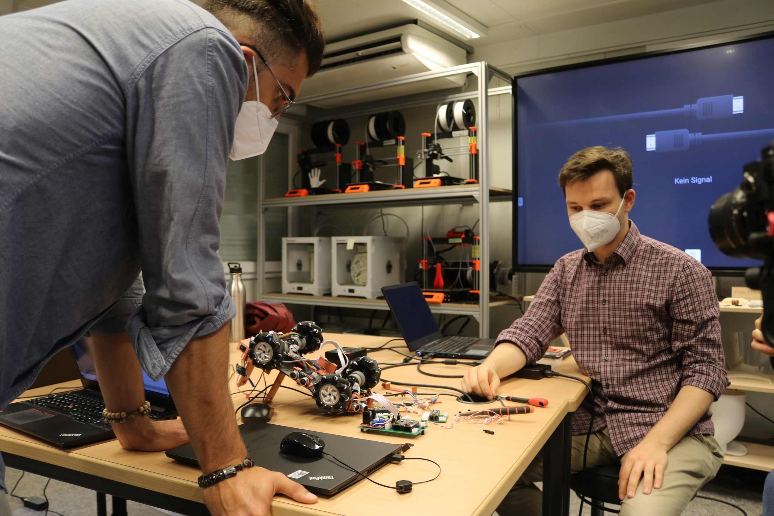 Zwei Mäner bauen einen Roboter im Openlab Hamburg